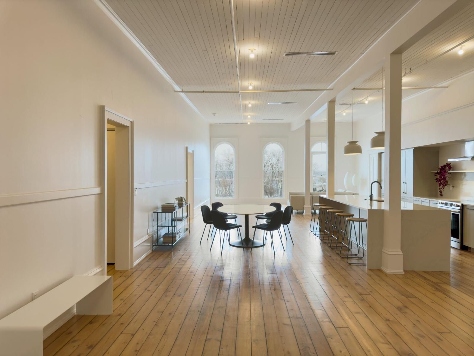 Finished open-plan suite with arched windows and original wood floors